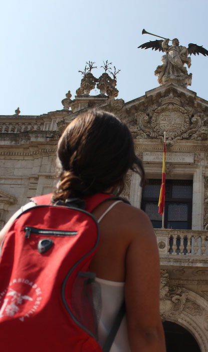 Estudiante frente a la puerta del Rectorado en la Universidad de Sevilla